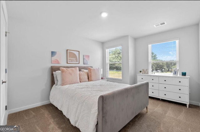 carpeted bedroom with visible vents and baseboards