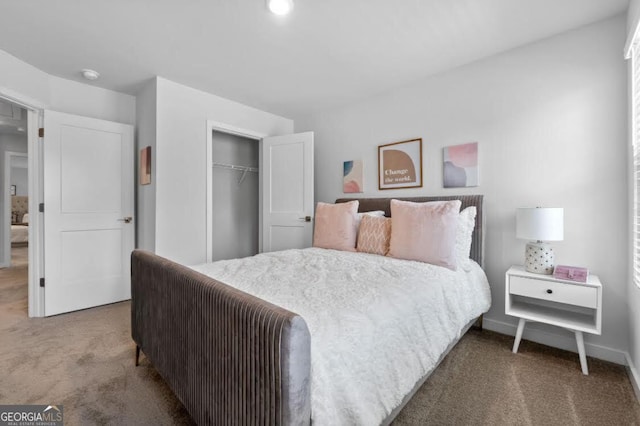 carpeted bedroom with a closet and baseboards