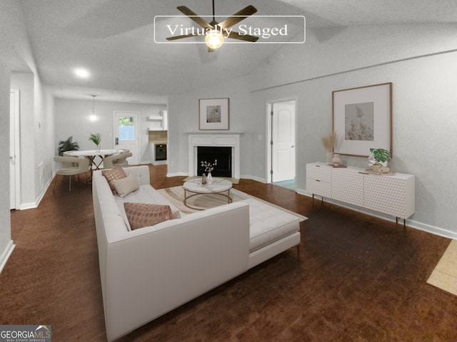 living room with ceiling fan, lofted ceiling, and dark colored carpet