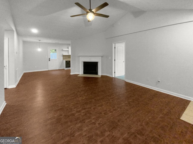 unfurnished living room featuring lofted ceiling, dark carpet, and ceiling fan