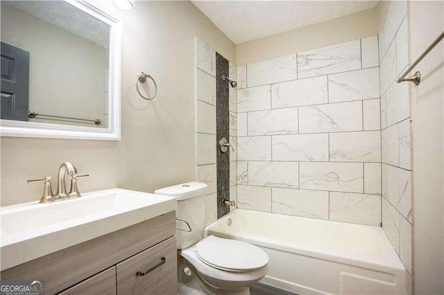 full bathroom with vanity, tiled shower / bath combo, a textured ceiling, and toilet