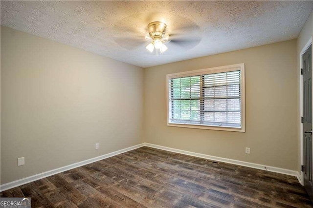 empty room with dark wood-type flooring, ceiling fan, and a textured ceiling