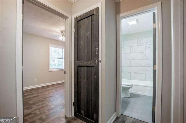 bathroom with shower with separate bathtub, ceiling fan, a textured ceiling, hardwood / wood-style flooring, and toilet