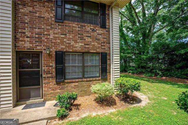 view of exterior entry with a yard