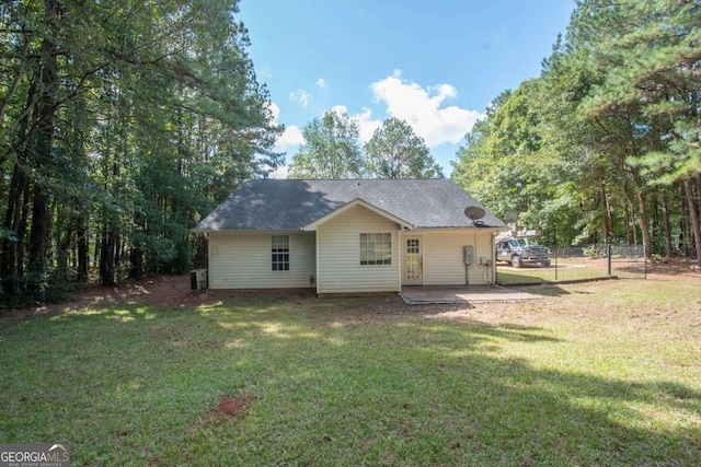 back of house featuring a yard, central AC unit, and a patio area