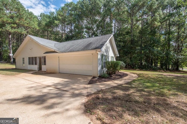 view of side of home featuring a yard and a garage