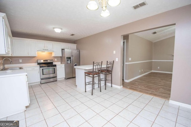 kitchen featuring white cabinets, sink, a textured ceiling, appliances with stainless steel finishes, and light wood-type flooring