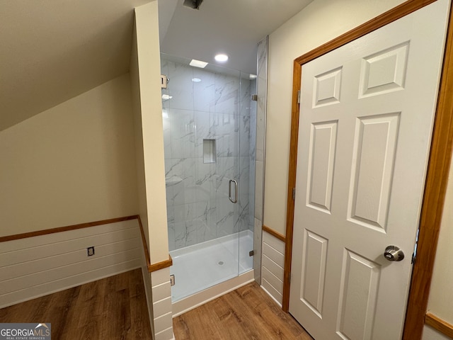 bathroom featuring a shower with shower door and hardwood / wood-style floors