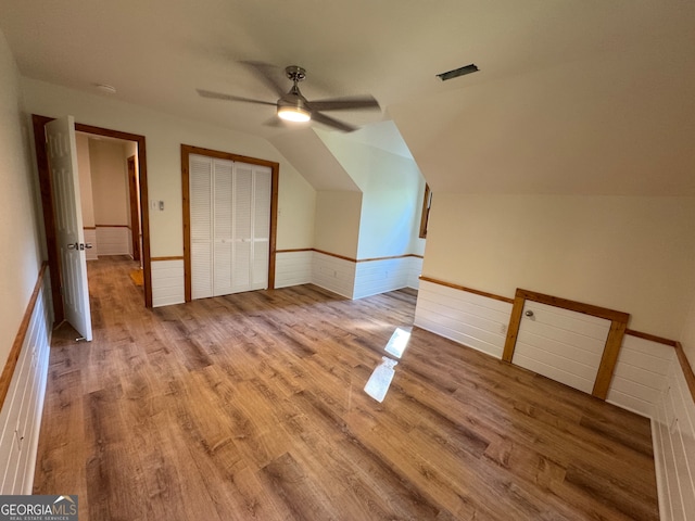 additional living space featuring light wood-type flooring, lofted ceiling, and ceiling fan