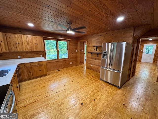 kitchen with ceiling fan, wood walls, stainless steel appliances, wooden ceiling, and light wood-type flooring