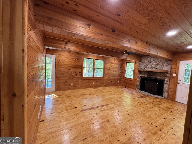 unfurnished living room featuring light wood-type flooring, wood walls, and wooden ceiling