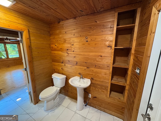 bathroom with wood ceiling, wooden walls, and toilet