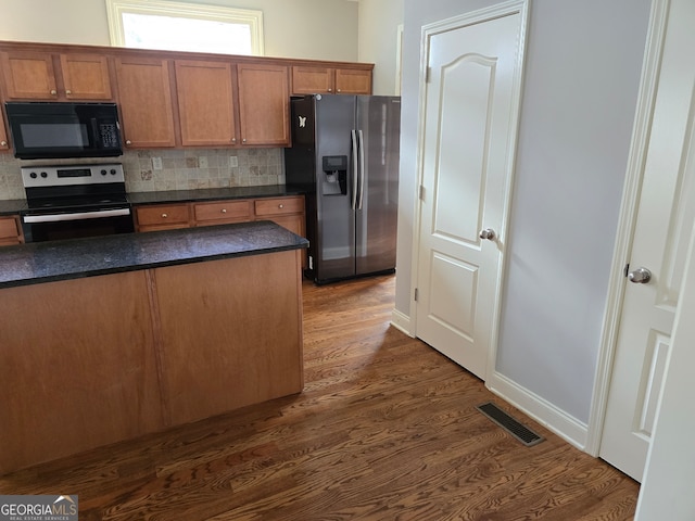 kitchen featuring decorative backsplash, stainless steel appliances, and dark hardwood / wood-style flooring