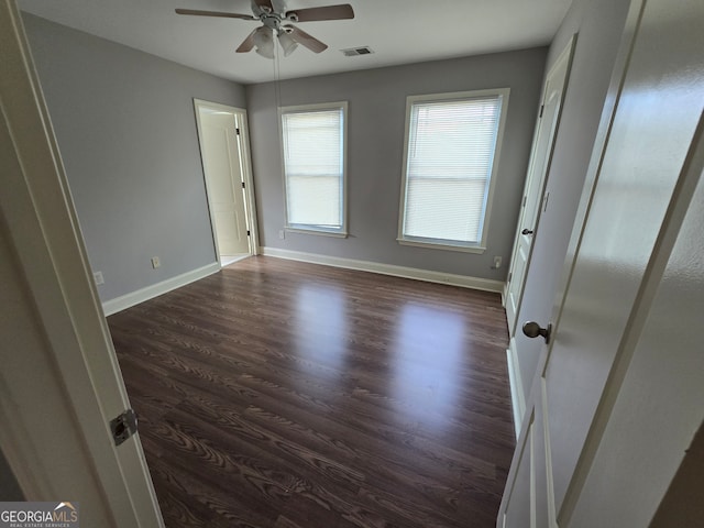 spare room with dark hardwood / wood-style flooring and ceiling fan