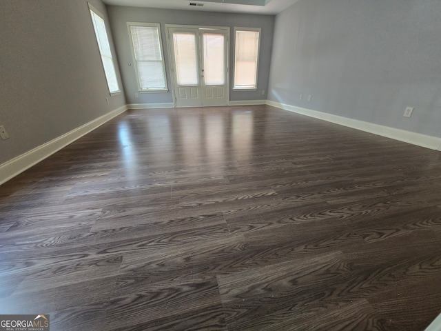 empty room featuring french doors and dark hardwood / wood-style flooring