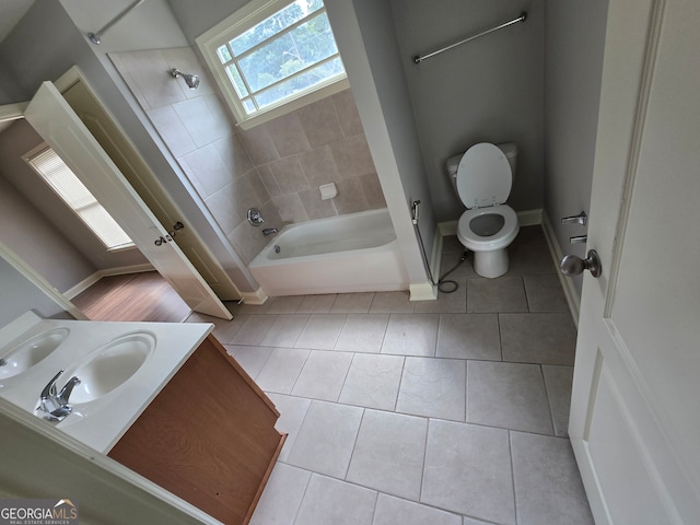 full bathroom featuring tile patterned flooring, vanity, toilet, and tiled shower / bath