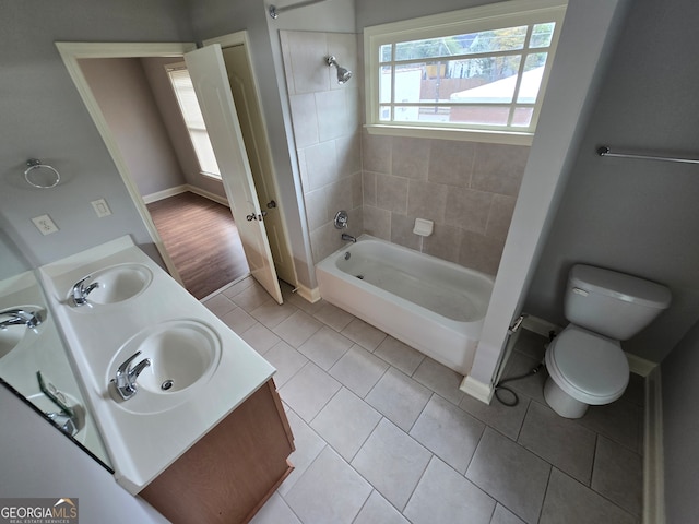 full bathroom with tiled shower / bath combo, vanity, toilet, and tile patterned floors