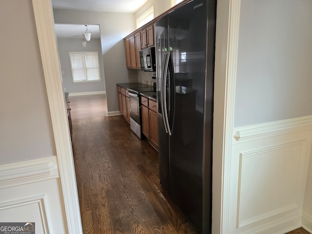 kitchen with refrigerator with ice dispenser, stainless steel electric stove, dark hardwood / wood-style flooring, and tasteful backsplash