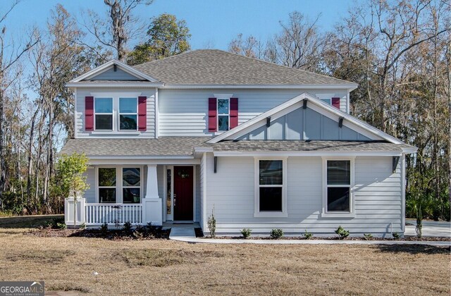 front facade with covered porch and a front yard