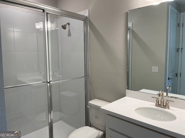 bathroom featuring walk in shower, vanity, and toilet