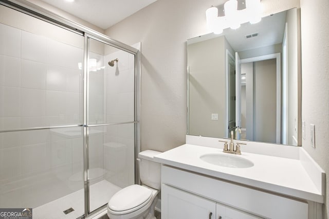 bathroom featuring vanity, an enclosed shower, and toilet