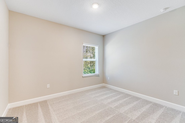 carpeted spare room with a textured ceiling