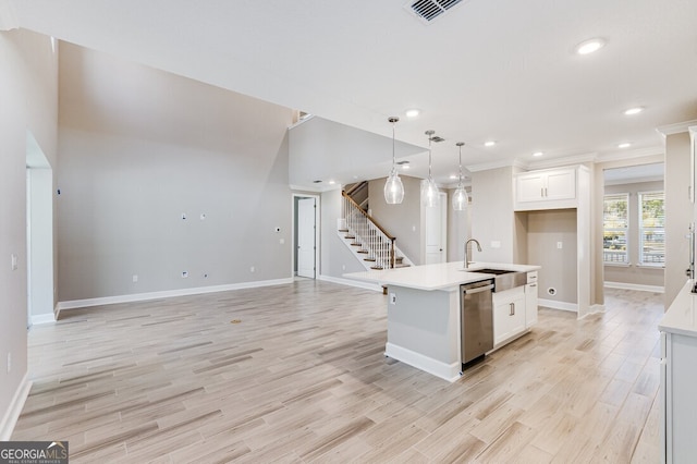 kitchen with white cabinetry, a kitchen island with sink, sink, dishwasher, and pendant lighting