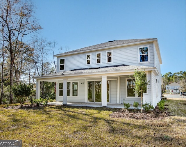 rear view of property featuring a lawn