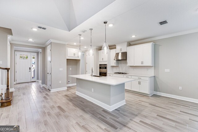 hall featuring light wood-type flooring, an inviting chandelier, and crown molding