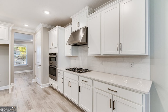 kitchen featuring light hardwood / wood-style floors, stainless steel appliances, white cabinets, ornamental molding, and decorative backsplash