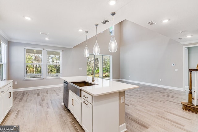 kitchen with white cabinets, an island with sink, dishwasher, and decorative light fixtures