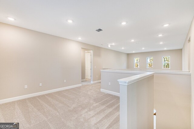 kitchen featuring hanging light fixtures, appliances with stainless steel finishes, an island with sink, white cabinets, and light wood-type flooring