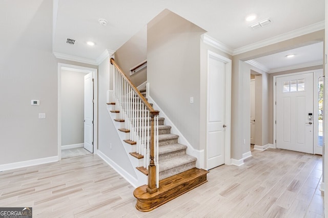 foyer entrance featuring light wood-type flooring and crown molding