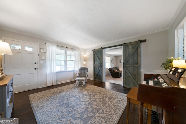 entrance foyer featuring a barn door, dark hardwood / wood-style floors, and crown molding