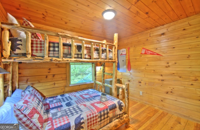 bedroom featuring wooden walls, wood ceiling, and hardwood / wood-style flooring