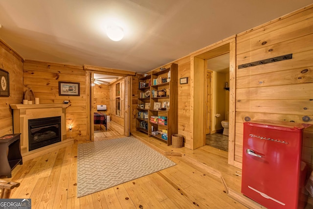 interior space with light hardwood / wood-style flooring and wooden walls