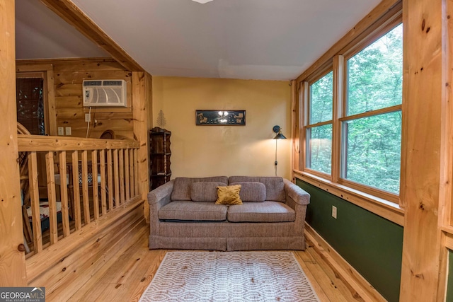 living room with hardwood / wood-style flooring and an AC wall unit