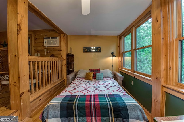 bedroom with a wall mounted AC and ceiling fan