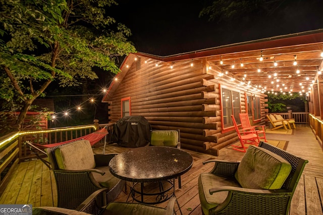 patio at twilight featuring area for grilling and a deck