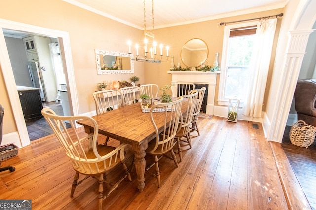 1651 Mergendollar Rd, Good Hope, GA 30641 - dining room featuring an inviting chandelier, ornamental molding, a fireplace, visible vents, and hardwood / wood-style flooring