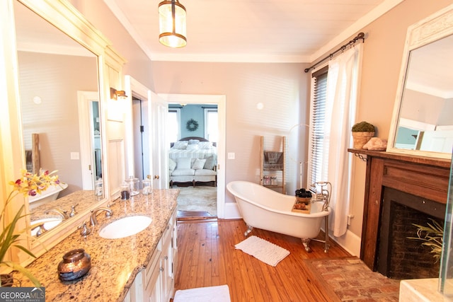 1651 Mergendollar Rd, Good Hope, GA 30641 - bathroom featuring a fireplace, a freestanding tub, vanity, baseboards, and hardwood / wood-style flooring