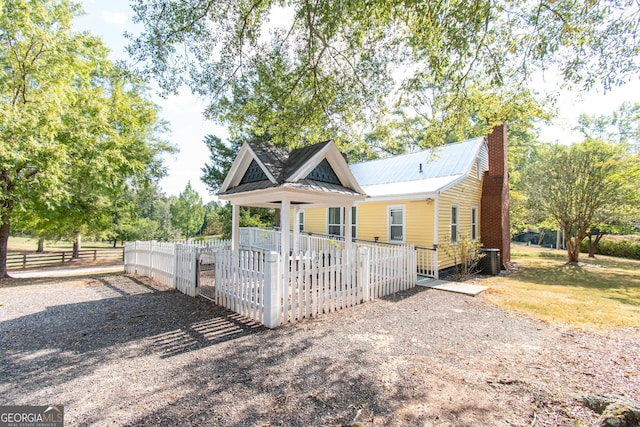 1651 Mergendollar Rd, Good Hope, GA 30641 - view of front facade featuring a fenced front yard, central AC, metal roof, a chimney, and driveway