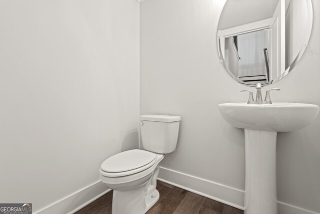 bathroom with hardwood / wood-style flooring and toilet