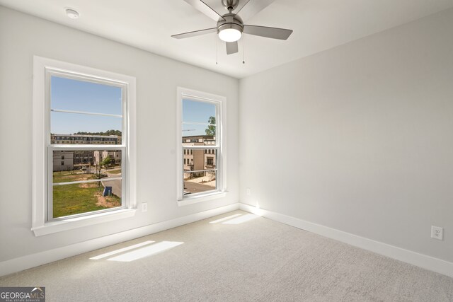 carpeted empty room featuring ceiling fan