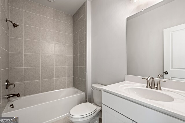 full bathroom featuring tiled shower / bath combo, vanity, and toilet