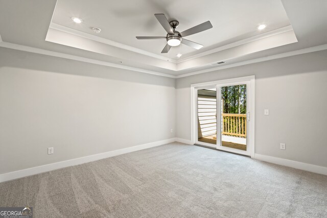 carpeted empty room featuring ceiling fan, a tray ceiling, and crown molding