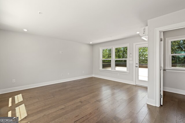 spare room with dark hardwood / wood-style floors and a wealth of natural light