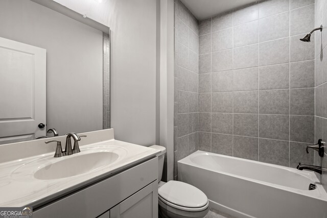 full bathroom with tiled shower / bath combo, vanity, and toilet