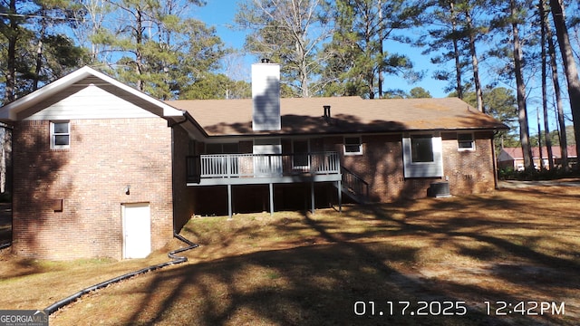 back of property with a deck, a yard, and central AC unit