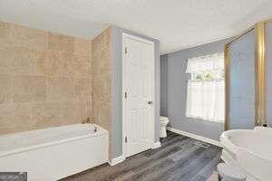 bathroom featuring a bathtub, toilet, and hardwood / wood-style floors